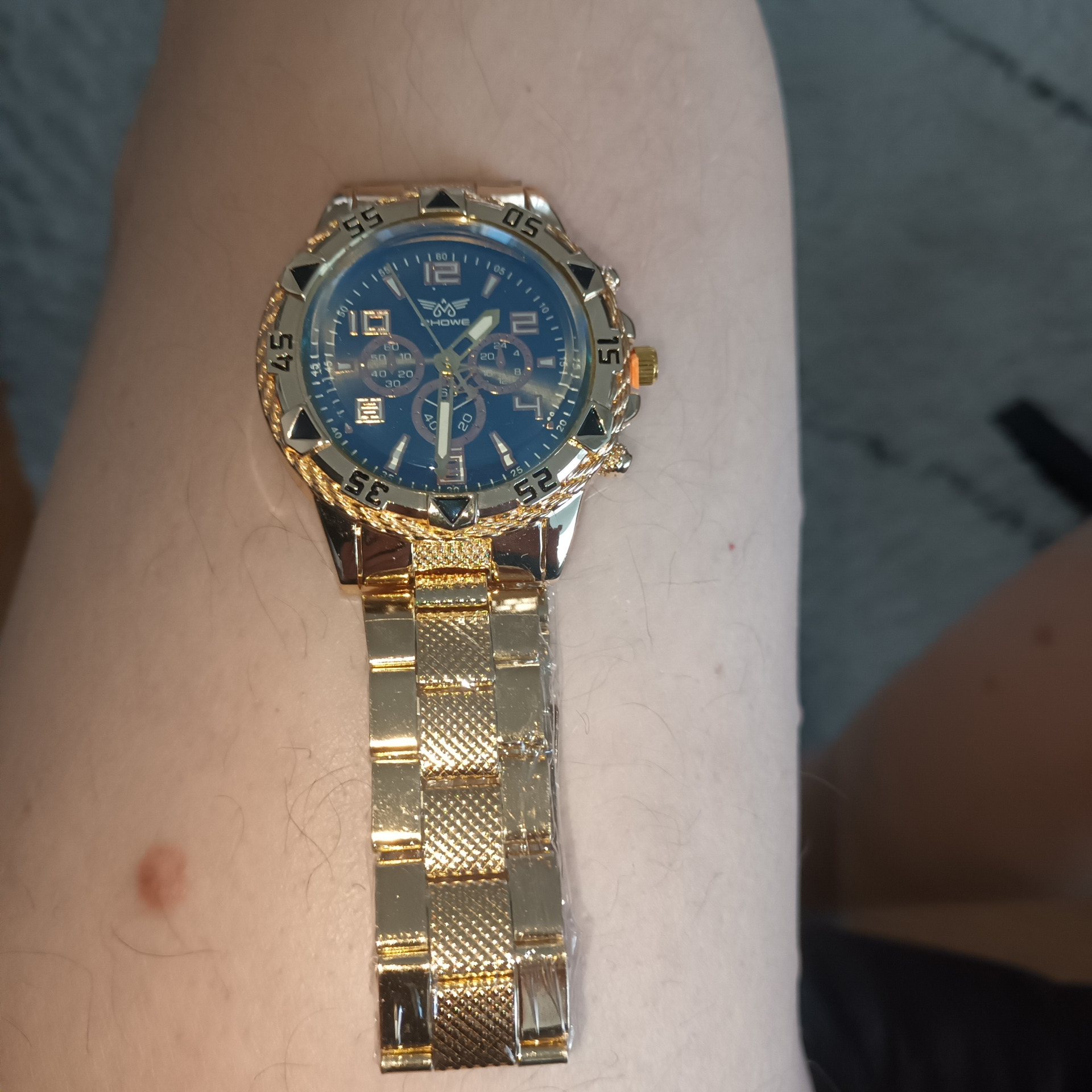 Kullanvärinen rannekkeella varustettu sinitaustainen kello